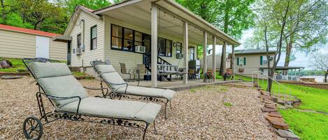 A covered patio with outdoor furniture, a covered deck, and a view of a lake.