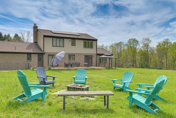 A house with a patio area featuring outdoor seating and a fire pit.