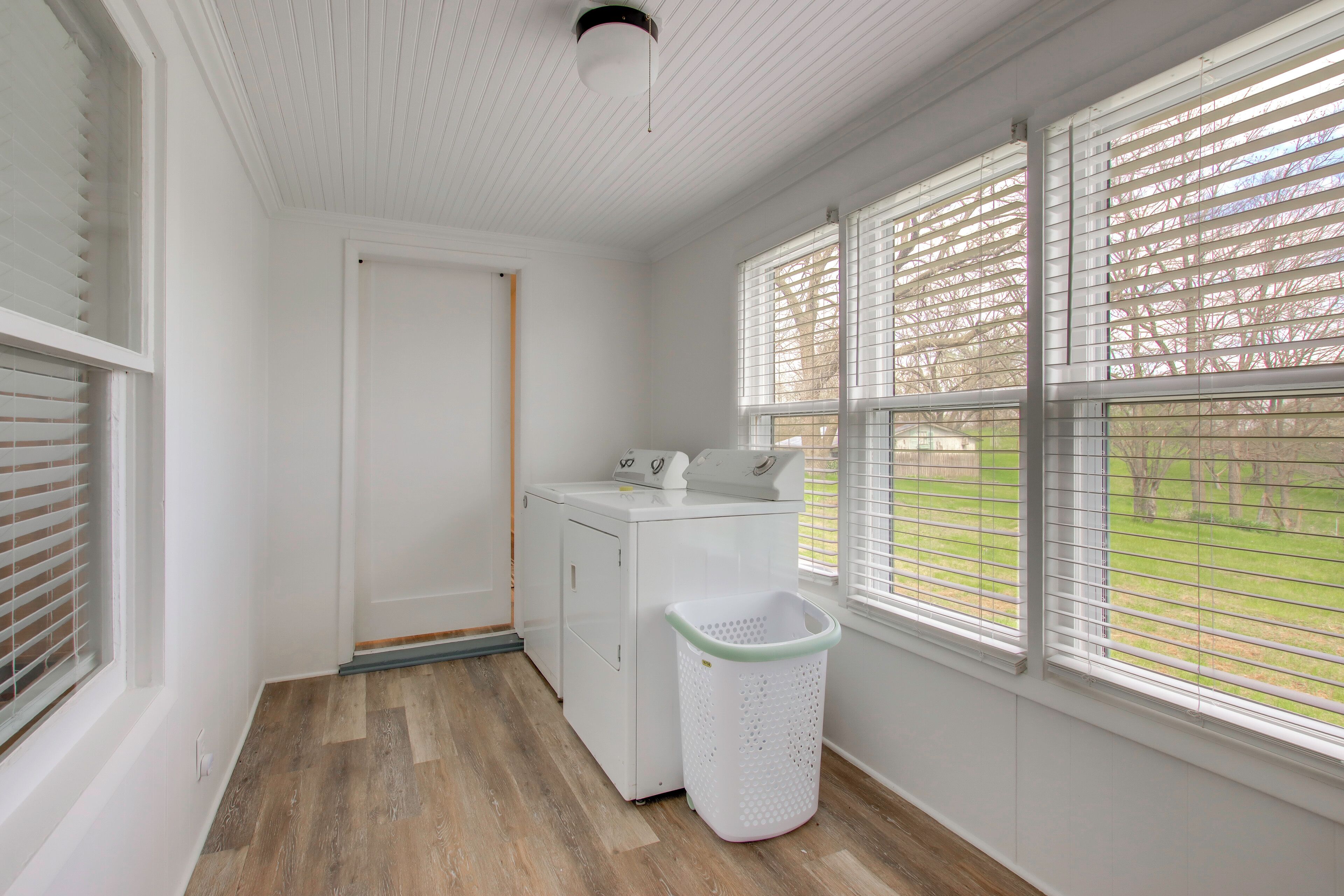 A laundry room with a washing machine, a dryer, and a laundry basket.