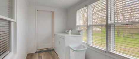A laundry room with a washing machine, a dryer, and a laundry basket.