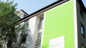 A modern building with a green facade and a sign for 'best price hotels.' - 2 Person Holiday Park Home in Bendorf (Bendorf)