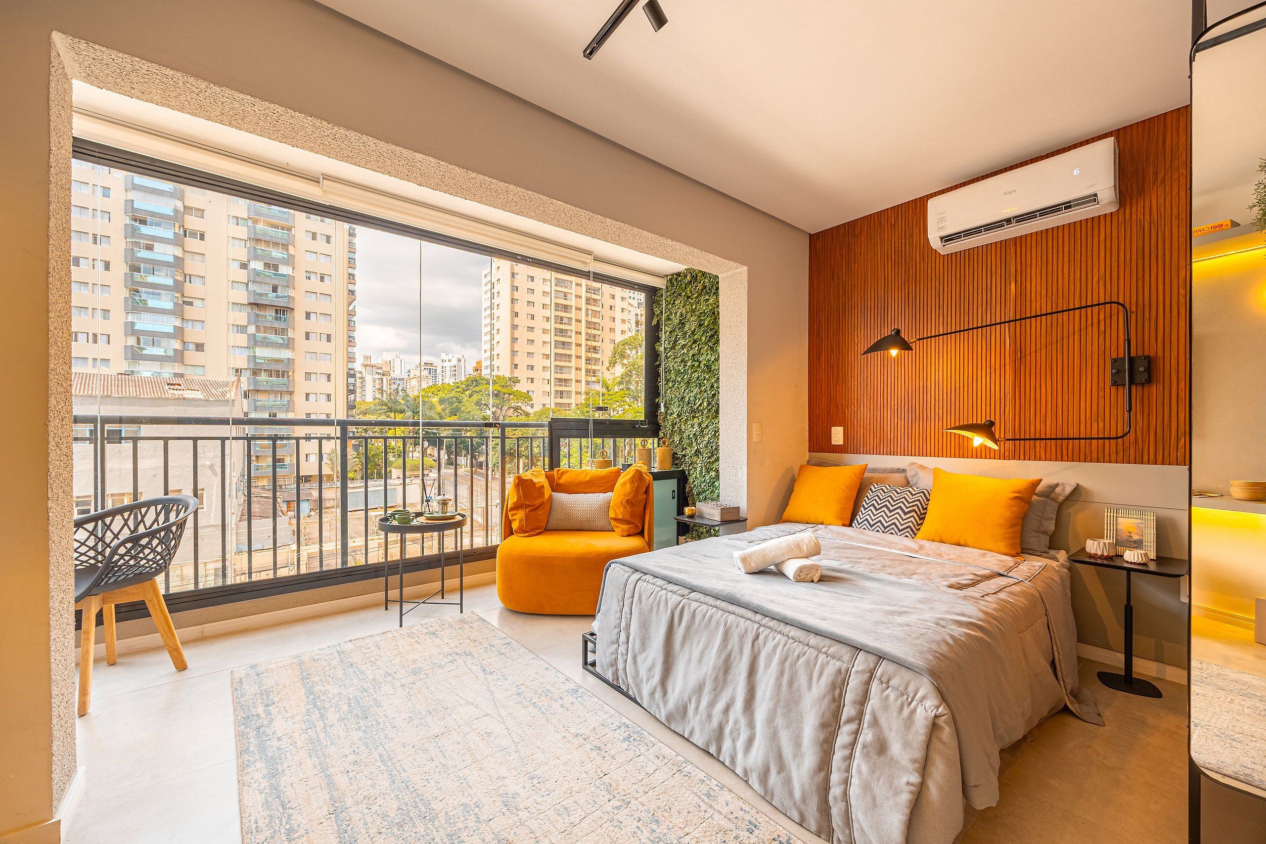 A modern bedroom with a large window, a bed, a chair, and a small table.