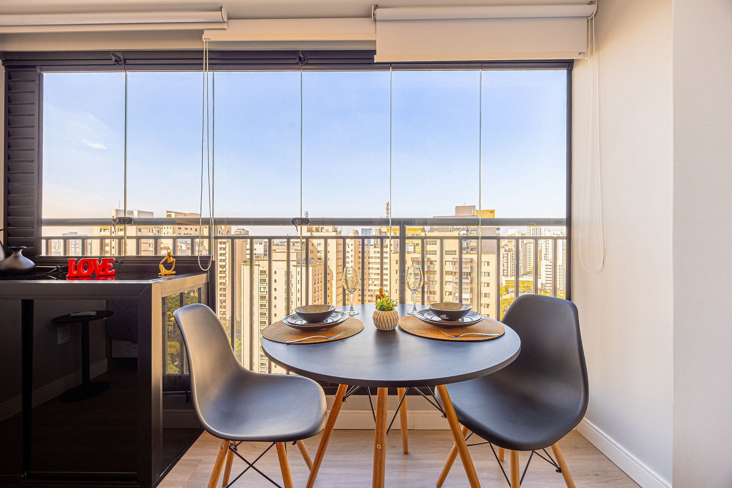 Eine moderne Küche mit Essbereich, Blick auf die Stadt und einem Balkon mit Tisch und Stühlen.
