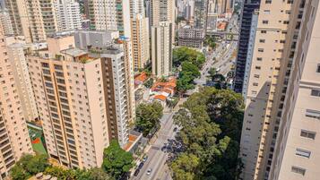 A high-rise urban area with multiple buildings, a street with cars, and trees.