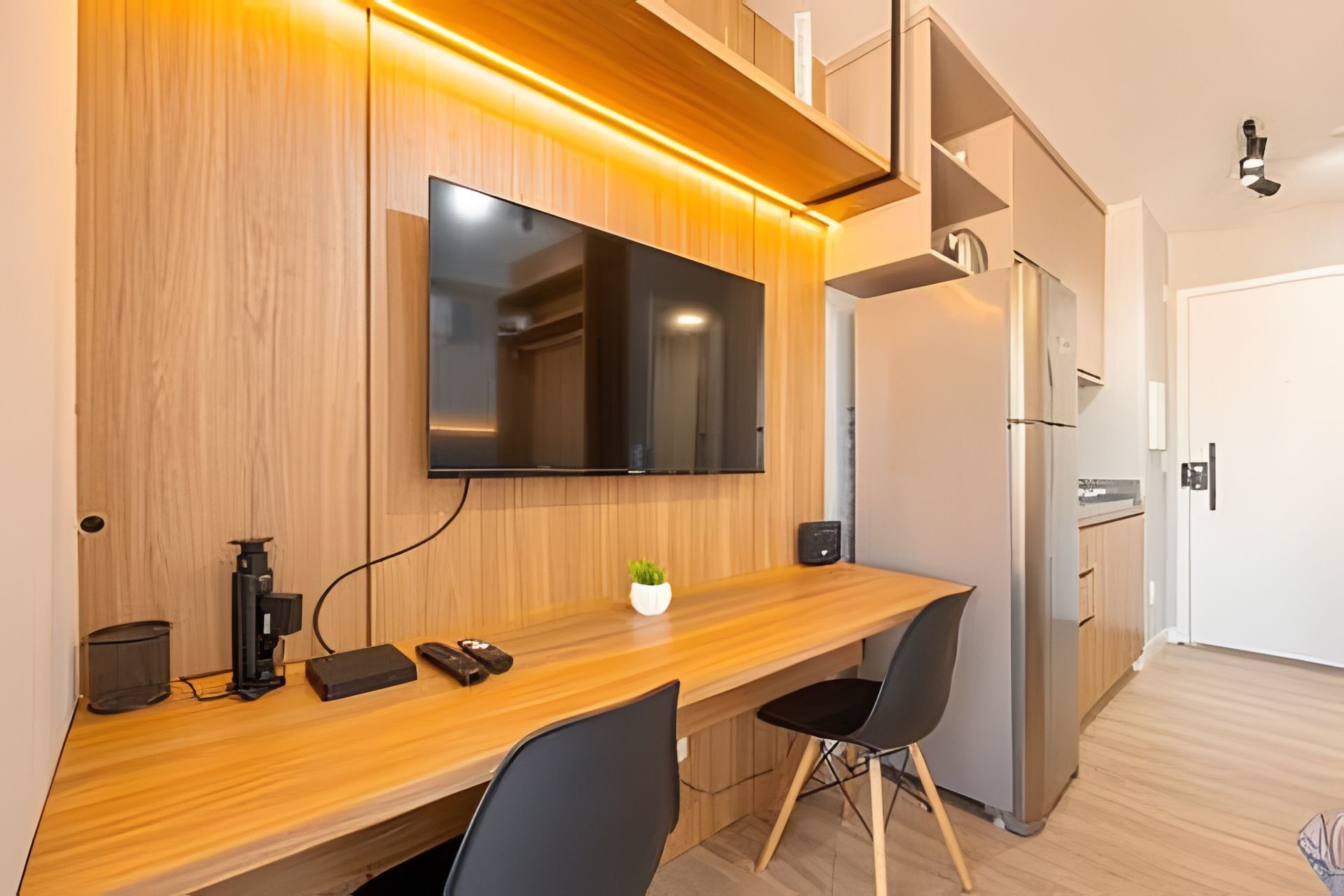 A modern kitchen with a built-in refrigerator, a microwave, and a wooden countertop.