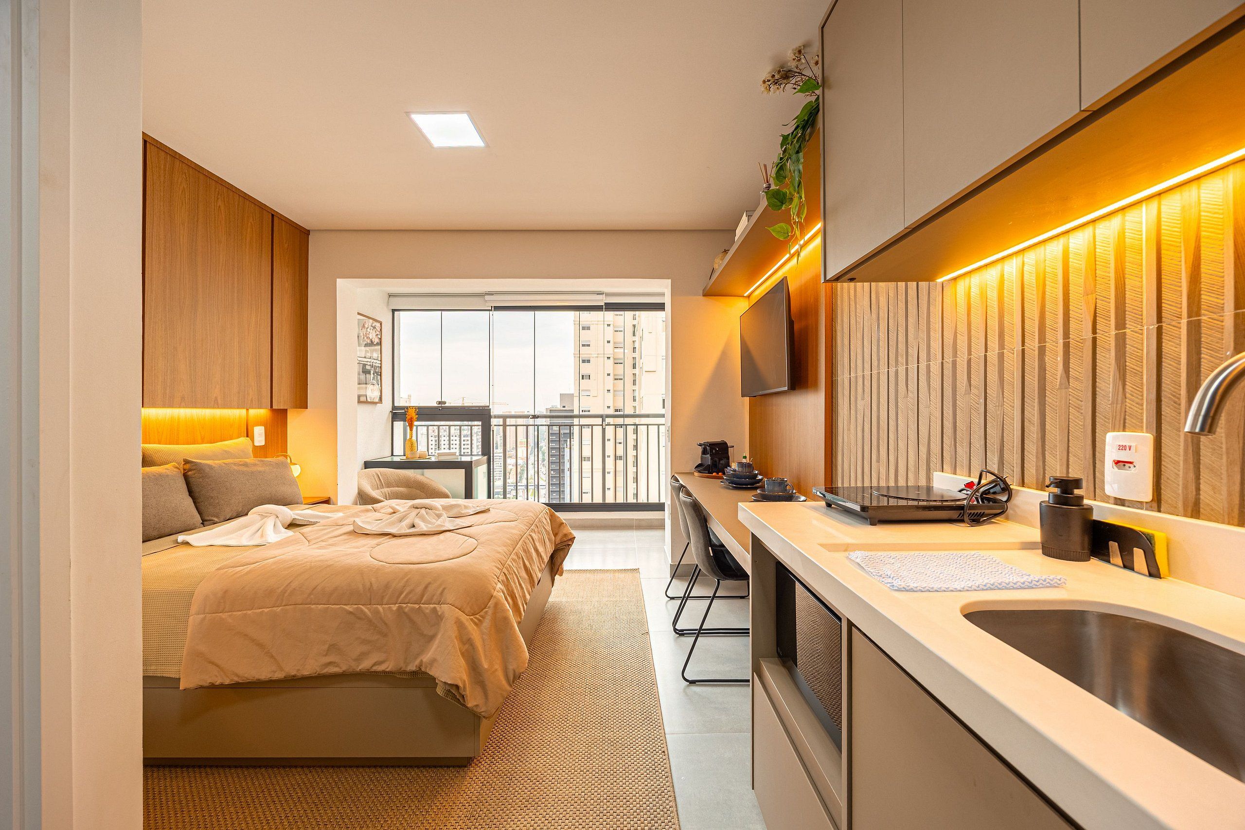 A modern bedroom with a bed, bedside table, and a view of the city.