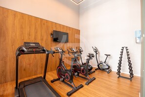 Gimnàs amb equip d'exercici, incloent cintes de córrer, bicicletes estàtiques i pèses.
