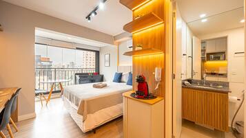 Ein modernes Hotelzimmer mit Bett, Nachttisch und Blick auf die Stadt.