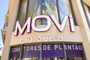 A building with a large sign reading 'MOVI CAMPO BELO' and 'CORR TORES DE PLANTÃO'. - Hospedez - Estudios Campo Belo Movi (São Paulo)