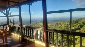 Una habitación con ventanas amplias que ofrecen vistas a un paisaje montañoso.