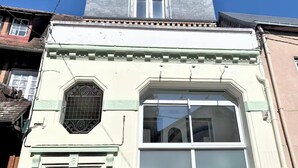 A building with a large window, a door, and a small balcony.