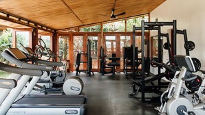 A gym with treadmills, weight machines, and a ceiling fan. - Heaven Restaurant and Boutique Hotel (Kigali)