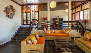 A spacious lobby with a staircase, wicker furniture, and a view of the outdoors. - Heaven Restaurant and Boutique Hotel (Kigali)