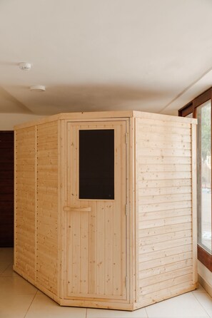 A wooden sauna with a sliding door, a window, and a ceiling light fixture. - Heaven Restaurant and Boutique Hotel (Kigali)