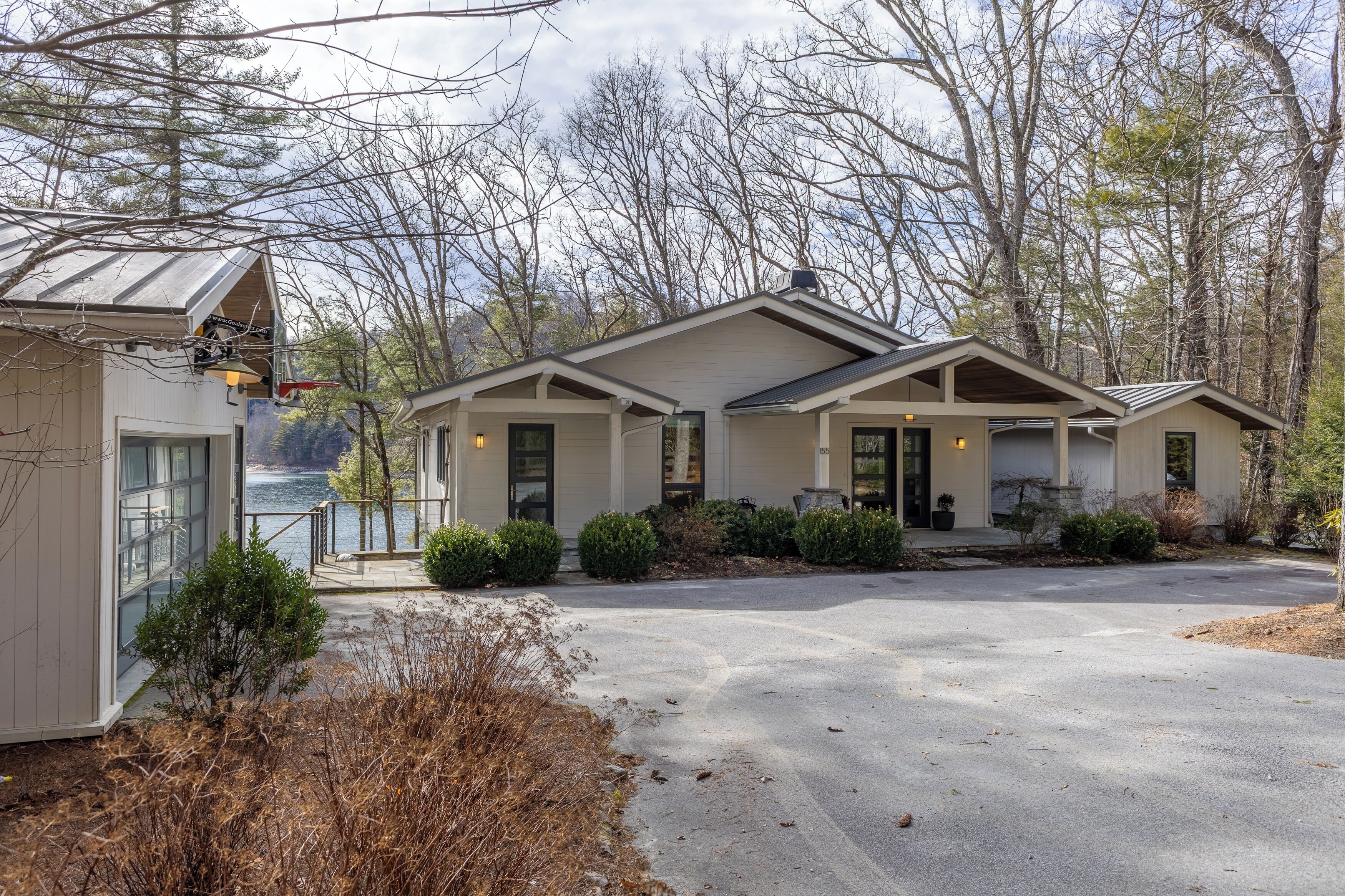 A two-story building with a covered patio, a garage, and a driveway.