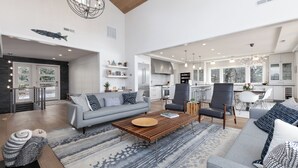 A spacious living area with a grey sofa, a wooden coffee table, and a patterned rug.