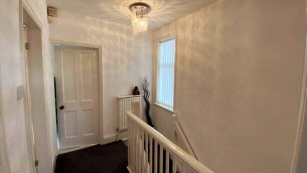 A hallway with a white door, a radiator, a window, and a staircase with a white railing. - Room-single Cosy Room Near CBS Arena and (Coventry)
