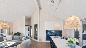 A modern interior with a dining area, sofas, and pendant lights. - 5 Star Holiday Home in Idestrup (Idestrup)