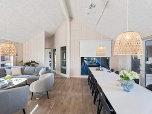 Ein modernes Interieur mit Essbereich, Sofas und Pendelleuchten.