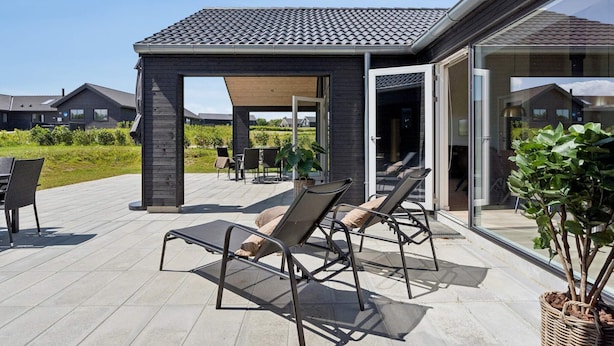 A covered outdoor patio with lounge chairs and a pergola. - 5 Star Holiday Home in Idestrup (Idestrup)