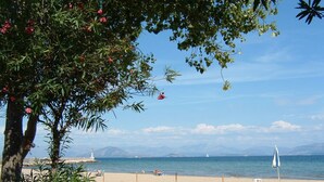 A beach with a clear view of the sea, a lighthouse, and distant mountains. - Serene studio with AC in lovely Lefkimmi Corfu (Lefkimmi Corfu)