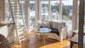 A cozy room with a white couch, a glass table, and a wooden floor. - 5 Star Holiday Home in Ingaro (Ingaro)