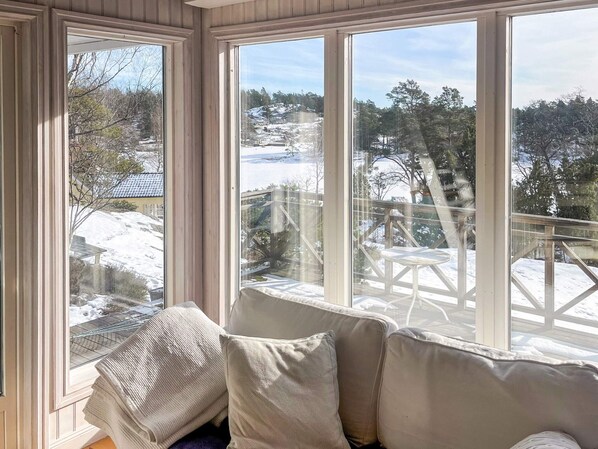 A room with large windows, a cushioned bench, and a view of a snowy landscape. - 5 Star Holiday Home in Ingaro (Ingaro)