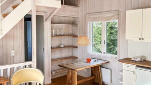 A cozy room with a wooden table, a chair, a window with a view, and built-in shelves. - 5 Star Holiday Home in Ingaro (Ingaro)