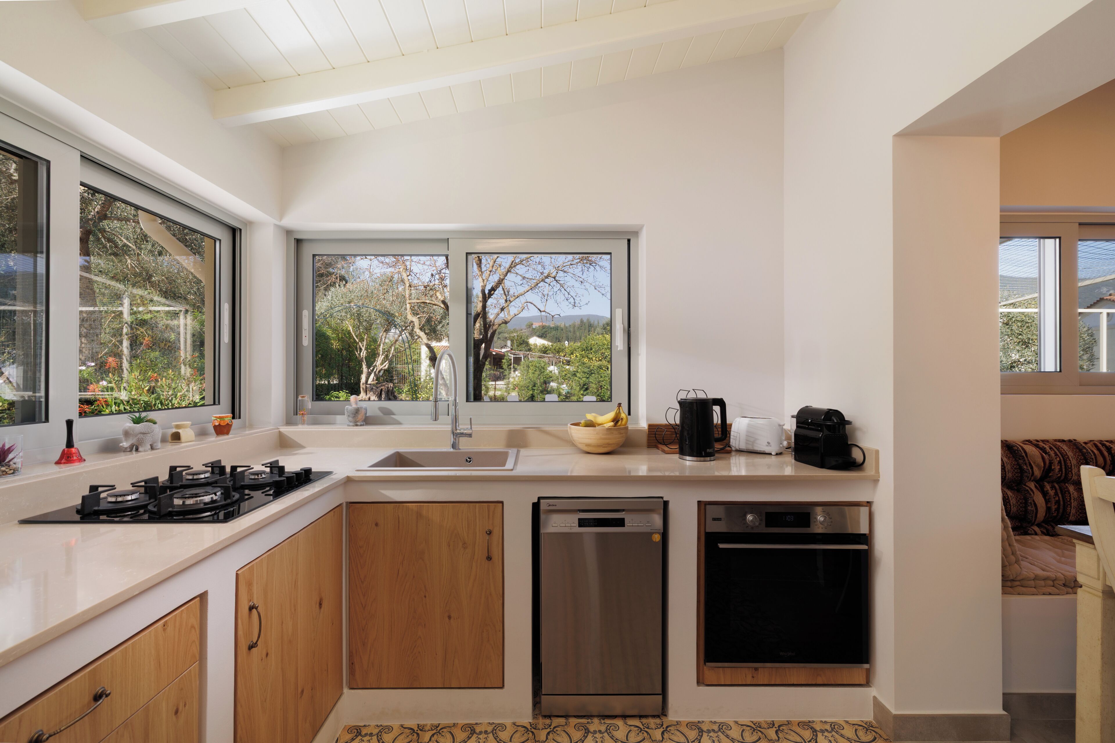 Una cocina moderna con un ventanal grande, electrodomésticos integrados y vistas al exterior.
