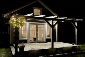 A house with a covered porch, a window with curtains, and a small outdoor seating area. - Holiday cottages by the sea in an oasis of peace (Smoldzino)