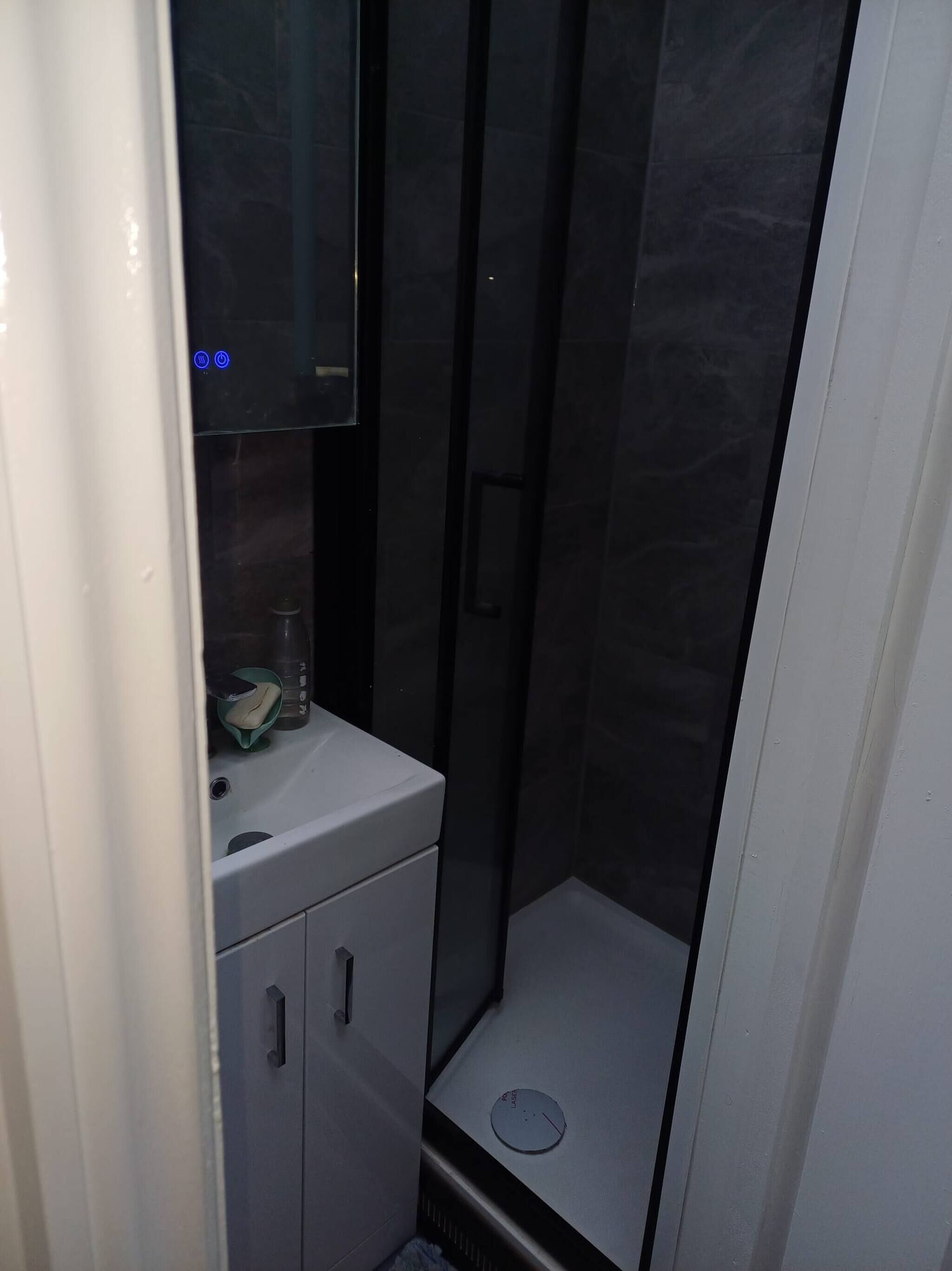 Ein Badezimmer mit Spiegel, Waschbecken, Handtuch und Toilette.