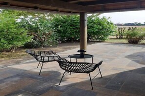 An outdoor patio with two metal chairs and a small round table. - Ferienwohnung in Petersdorf auf Fehmarn (Petersdorf)