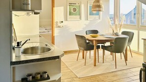Una cocina moderna con un fregadero, una mesa de comedor, sillas y una ventana con vistas.