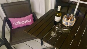 Ein Tisch mit einer Weinflasche, zwei Weingläsern und einem Korb voller Weinkorken.