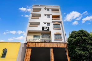 Un edificio de hotel de varios pisos con balcones, un cartel que dice 'HOTELO' y fachada de madera.