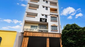 A multi-story hotel with balconies, a sign indicating it is a hotel, and a gated entrance. - Super Deluxe Room More Bimla Regency (Barakpur)