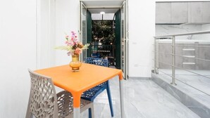 A dining area with a table, chairs, and a vase of flowers. - Vico Teresa 148 (Naples)
