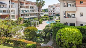 Un immeuble résidentiel doté de nombreux balcons, d’une piscine et de jardins bien entretenus.
