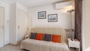 Une chambre d’hôtel avec un lit, une table de chevet et deux tableaux encadrés au mur.