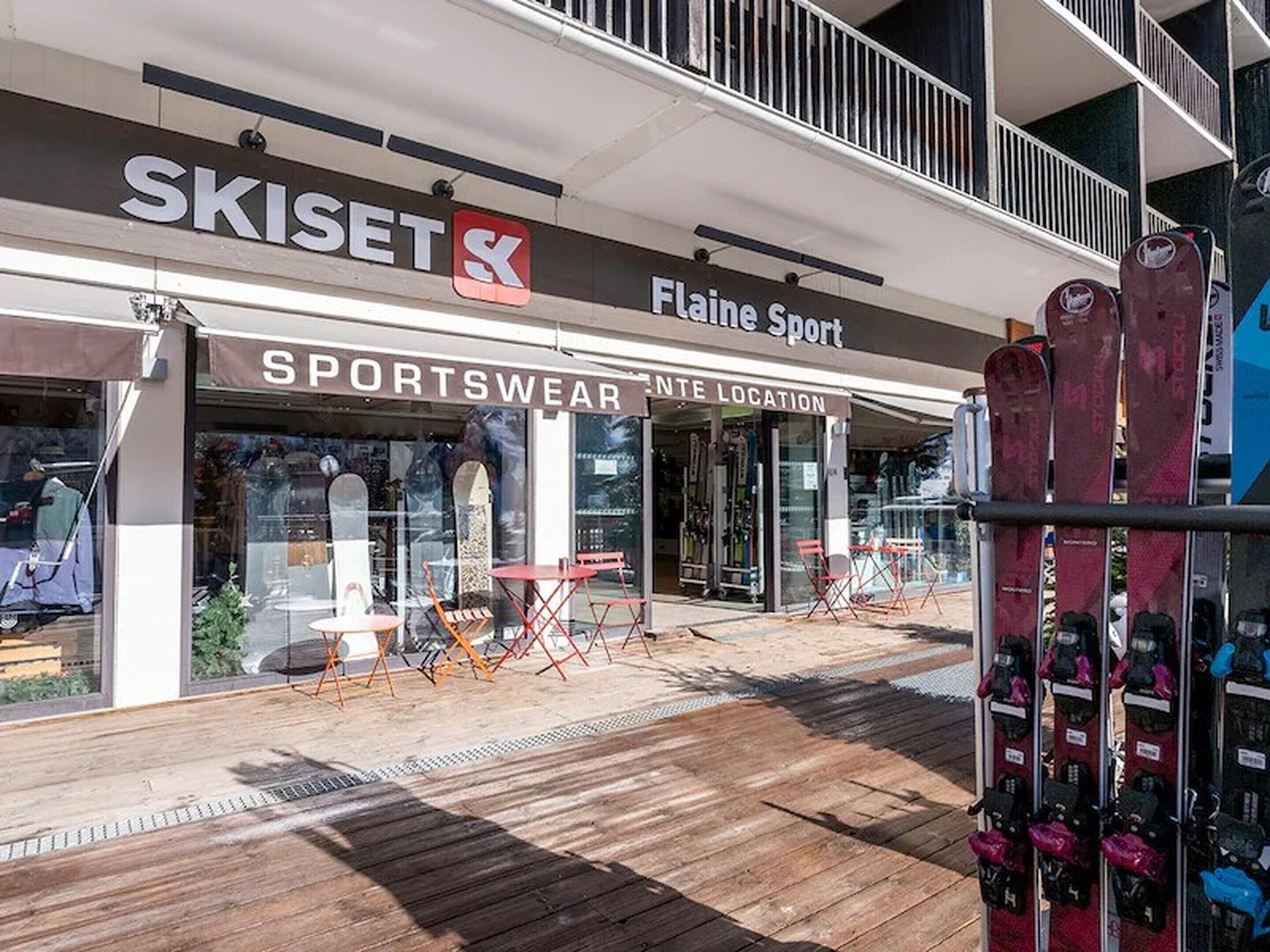 A storefront with signs for 'SKISET' and 'Flaine Sport' and a wooden deck area.