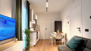 Un appartement moderne doté d’une télévision, d’un coin repas, d’une cuisine et d’un salon.