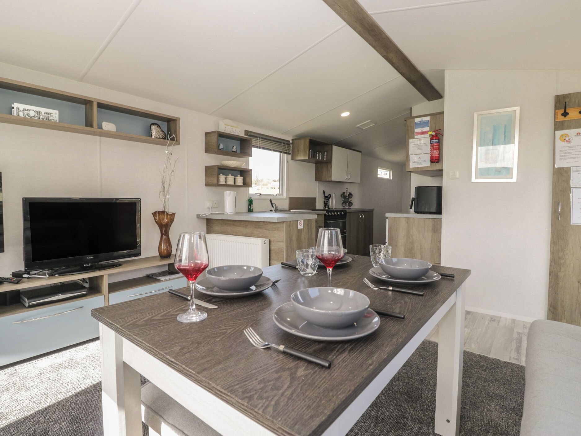 A modern kitchen with a dining area, a TV, and a fireplace.