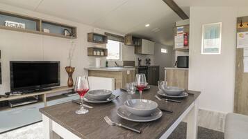 A modern kitchen with a dining area, a TV, and a fireplace.