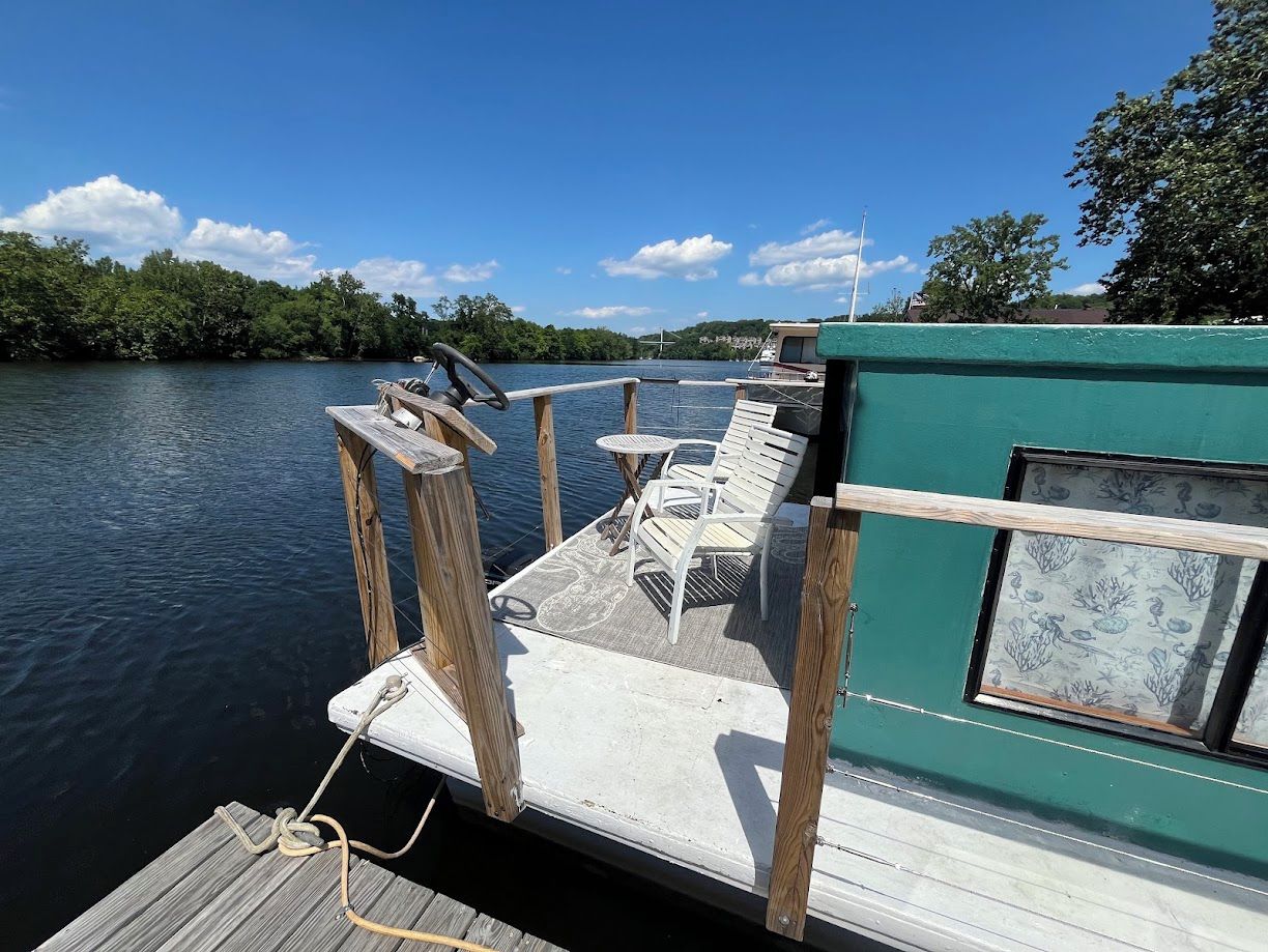 Um cais com um barco, uma pequena mesa e duas cadeiras.