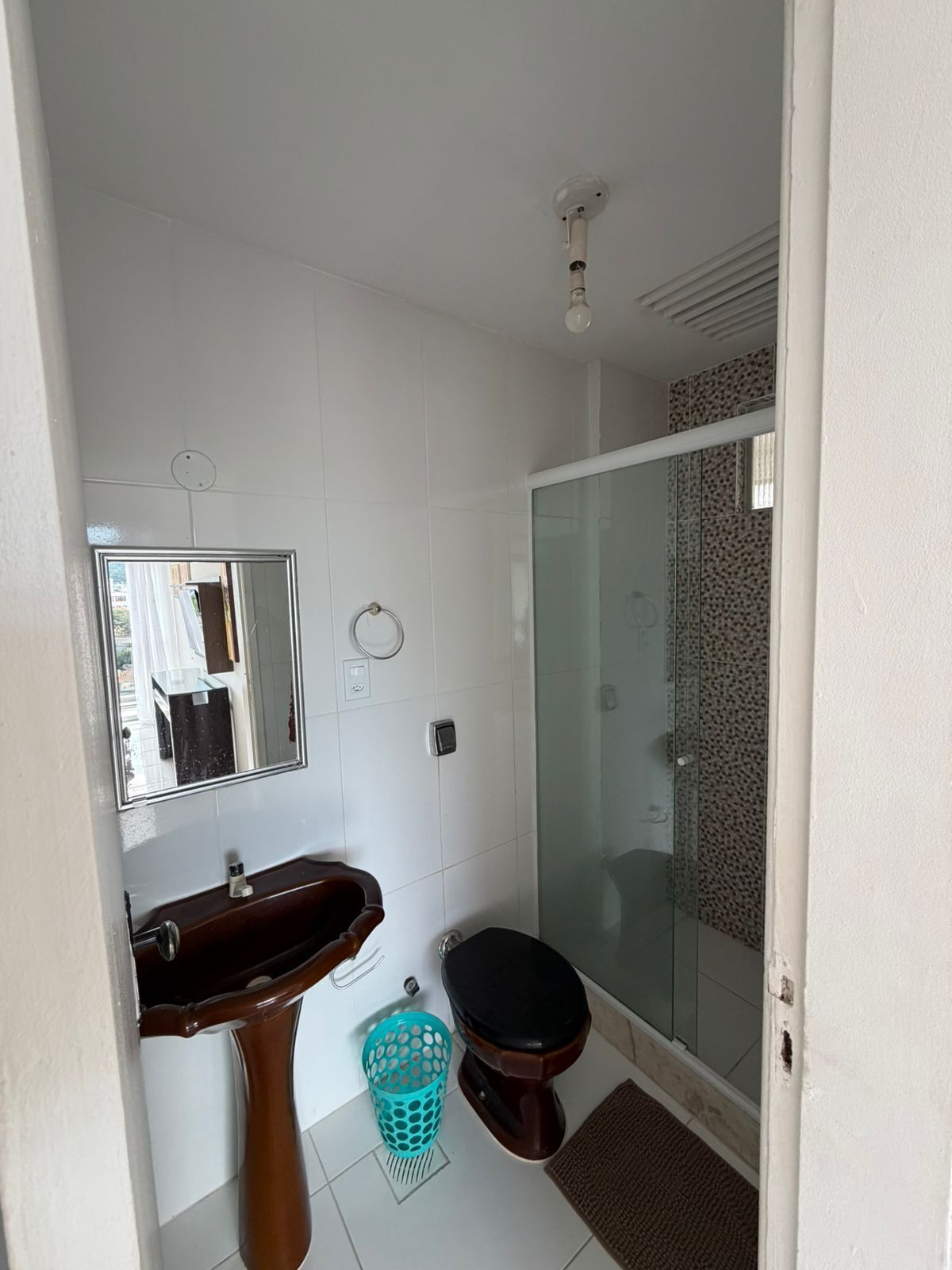 Ein Badezimmer mit Waschbecken, Spiegel, Toilette und Duschkabine.