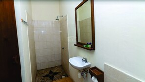 A small bathroom with a shower, a sink, and a mirror. - Villa Karang Homestay (Gili Air)