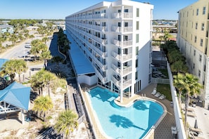 Ein mehrstöckiges Hotel mit Swimmingpool, Balkonen und Blick auf die Umgebung.