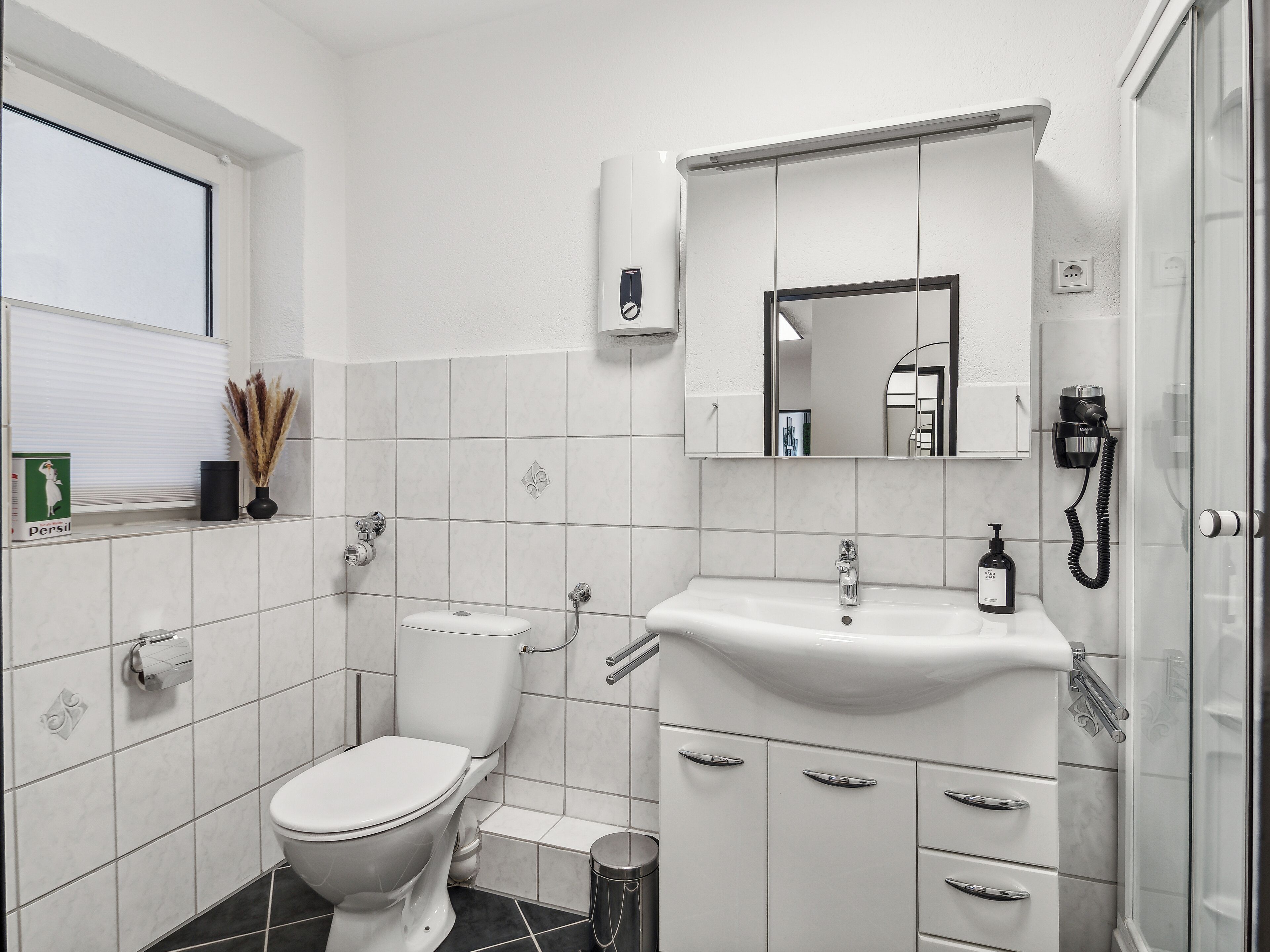 Ein modernes Badezimmer mit Toilette, Waschbecken und Dusche.