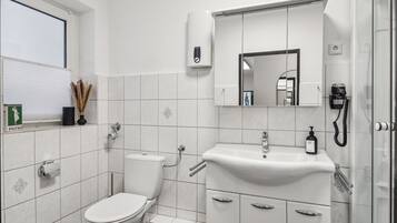 Ein modernes Badezimmer mit Toilette, Waschbecken und Dusche.