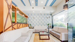 Un salon moderne avec un canapé d’angle, une table basse et un mur décoré d’un motif.